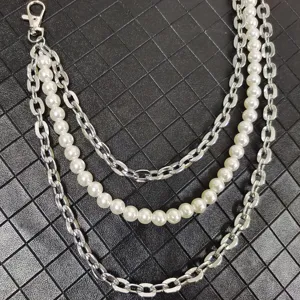 Detail shot of a multi-layer punk style waist chain featuring silver metal links and pearls.