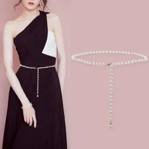 Pearl waist chain detail shot, elegant dress accessory with metal clasp and hanging chain beads.