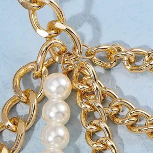 Nahaufnahme und Detailansicht der mehrlagigen goldenen Kette mit künstlichen Perlen.