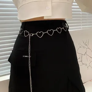 Close-up of stylish metal heart chain belt on black skirt, adjustable sexy waist body chain.