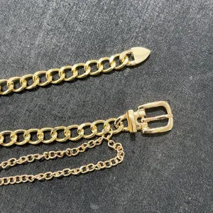 Detail view of punk gold metal chain belt buckle, stylish multilayer waist accessory for women.