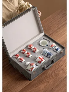 Detailed view of traditional Chinese ceramic tea set with koi fish pattern in grey gift box.