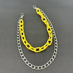 Nahaufnahme der doppelten Hip-Hop-Hosenkette, gelbes Acryl und silbernes Metall.