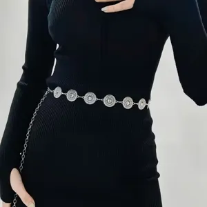 Close-up van een vintage zilveren metalen tailleketting met ingewikkelde ronde medaillons.