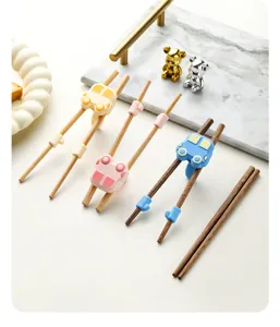 Gros plan détaillé de baguettes d'apprentissage en bois pour enfants avec aides en silicone.