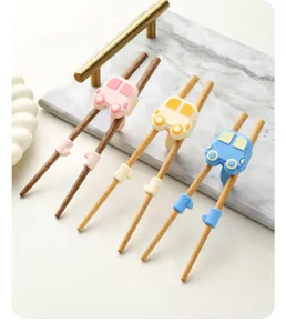 Baguettes d'apprentissage pour enfants avec aide en silicone de voiture. En bois sûr.
