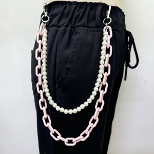 Détail en gros plan de la chaîne de pantalon double couche en perles et acrylique rose.