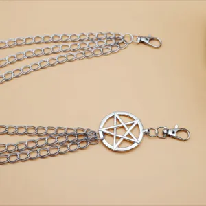Close-up of punk style multi-layer metal pants chain with pentagram pendant detail.