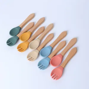 Détail cuillère et fourchette bébé en silicone, manche en bois pour l'alimentation.