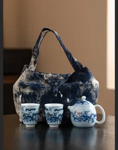 Detailaufnahme eines chinesischen Keramik-Teesets mit Drachenmuster und Tragetasche.