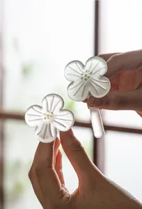 Frosted glass plum blossom tea needle and pillow detail shot, elegant tea ceremony accessory.