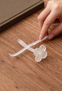 Frosted glass plum blossom tea needle and pillow detail shot, elegant Chinese tea ceremony set.
