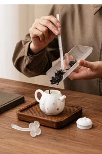 Detail shot of retro glazed tea pick and pillow set, elegant ceramic teapot on wood tray.