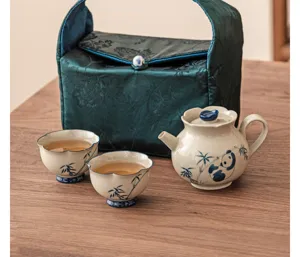Portable ceramic tea set with teapot and two cups featuring cute panda and bamboo design.