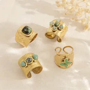 Detailed view of four vintage gold-plated wide adjustable rings with natural green stones.