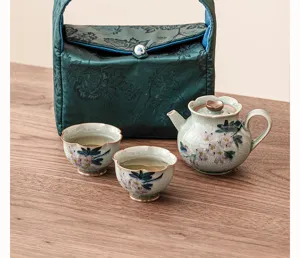 Detalle del juego de te de ceramica pintado a mano con tetera y tazas en primer plano.
