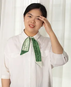 Detail shot of green floral skinny scarf, elegant ribbon necktie and hair accessory.