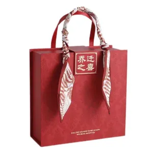 Red gift box with silk scarf handle, vintage housewarming packaging box for gifts and presents.