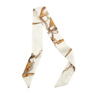 Detailed view of a chic French style silk twilly scarf with elegant golden chain print.