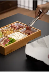 Detailed view of the bamboo partitioned serving tray showcasing fresh food ingredients inside.