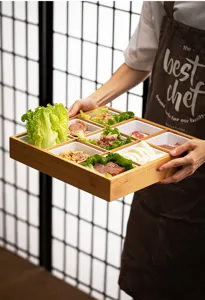 Bamboo 9-grid serving tray detail showcasing natural wood texture and ceramic compartment inserts.