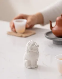 Vista dettagliata del leone in ceramica bianca da tè, elegante supporto per coperchio da tè.