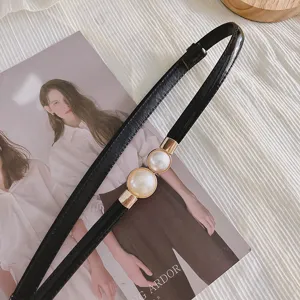 Élégante ceinture fine noire pour femme, dotée d'une boucle chic à double perle artificielle.