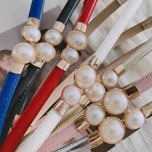 Vue détaillée d'une ceinture fine et élégante pour femme avec boucle décorative en perles.