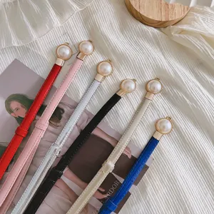 Vue détaillée de fines ceintures en cuir dotées de boucles métalliques nacrées élégantes.