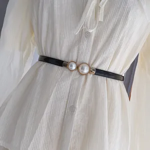 Vue détaillée d'une ceinture fine noire élégante dotée d'une double boucle en perles chic.