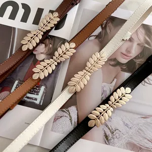 Detail shot of thin leather belts with elegant gold leaf buckles, perfect for dresses.