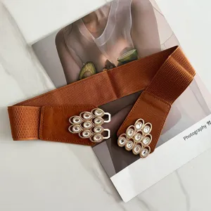Close-up of a stylish brown elastic waist belt with metal rhinestone interlocking buckle.