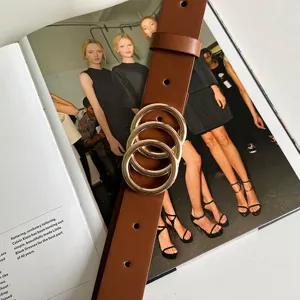 Women brown leather belt with stylish gold interlocking rings buckle for vintage outfits detail.
