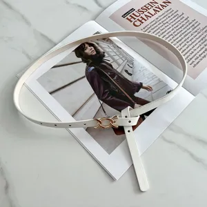 Dettaglio cintura sottile in pelle bianca, design con fibbia in metallo minimalista, accessorio.