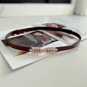 Slim brown leather belt with metallic gold leaf buckle, vintage waist chain dress accessory.