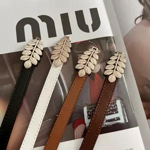 Close-up detail of thin women belts with metallic gold leaf buckles in multiple colors.