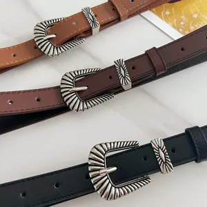 Close-up of vintage western leather belts with engraved silver buckles in multiple colors.