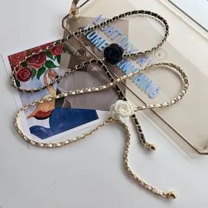 Nahaufnahme der eleganten Kamelienblüten Leder geflochtenen Ketten-Gürtel-Zubehörs.
