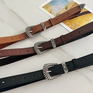 American vintage brown wide belt detail showing ornate silver metal buckle and textured leather.