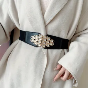 Detailed shot of women's wide elastic waist belt with ornate rhinestone metal buckle.
