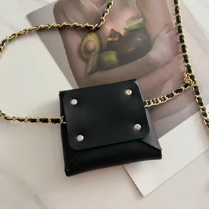 Black leather waist bag with gold woven chain strap stylish detail shot for women.