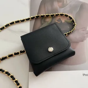 Chic black leather mini waist bag with woven gold chain strap, stylish trendy accessory for women.
