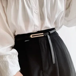 Dettaglio cintura sottile in pelle da donna, fibbia metallica minimalista, accessorio chic.