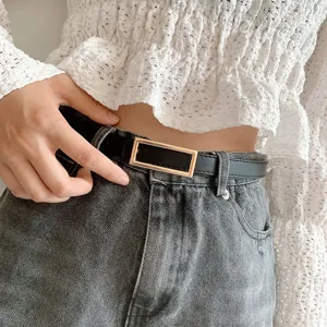 Minimalist black thin leather belt with gold rectangular metal buckle detail.