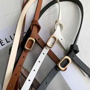 Minimalist thin leather belt detail, featuring a sleek rectangular metal buckle for women.