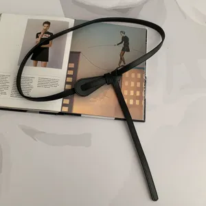 Ceinture fine en cuir noir minimaliste avec détail de nœud élégant pour robes et pulls.