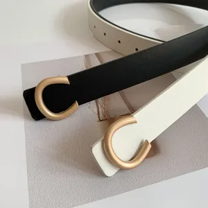 Gros plan détail ceinture fine pour femme boucle dorée en C, accessoire en cuir élégant.