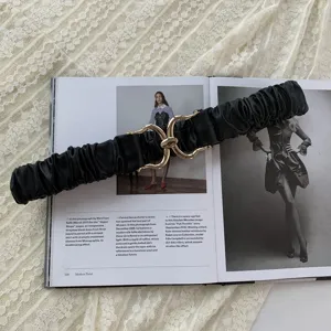 Cintura in vita elastica nera con fibbia metallica, dettaglio di accessorio per abiti.