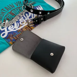 Detail view of the black PU leather small waist bag and metal chain belt flat lay setup.