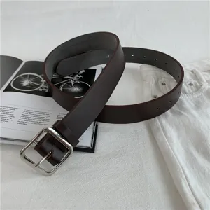 Women brown leather belt with silver square buckle, casual fashion waist belt detail.